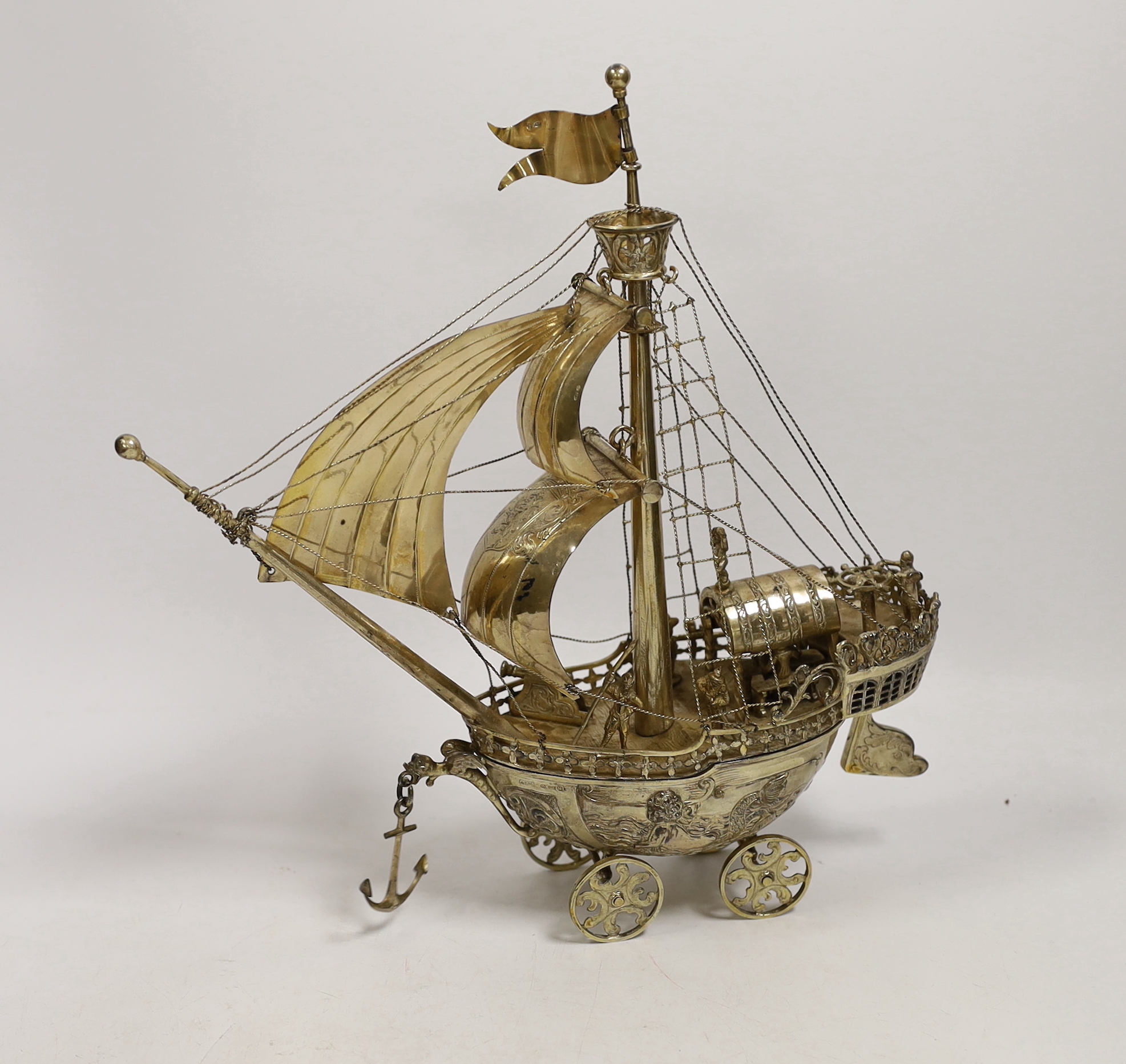 A late 19th/early 20th century Hanau silver gilt model of a Nef on four wheels, possibly by Neresheimer, import marks for A.P.M. London, 1926, height 29cm, gross weight 20.9oz, with detachable base.